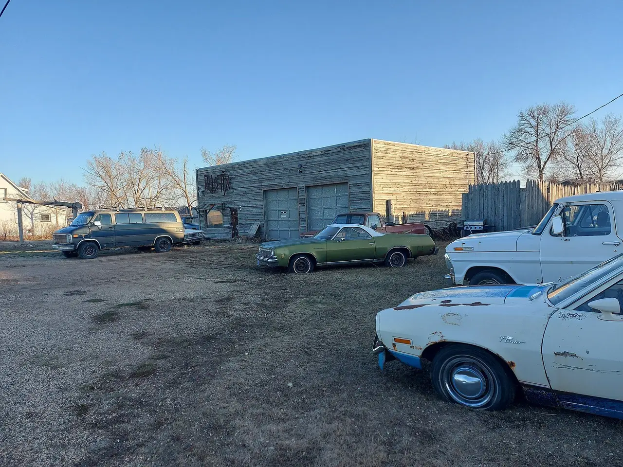 Old garage building and vintage vehicles at Main St and Railway Ave, 2025