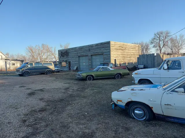 Old garage building and vintage vehicles at Main St and Railway Ave