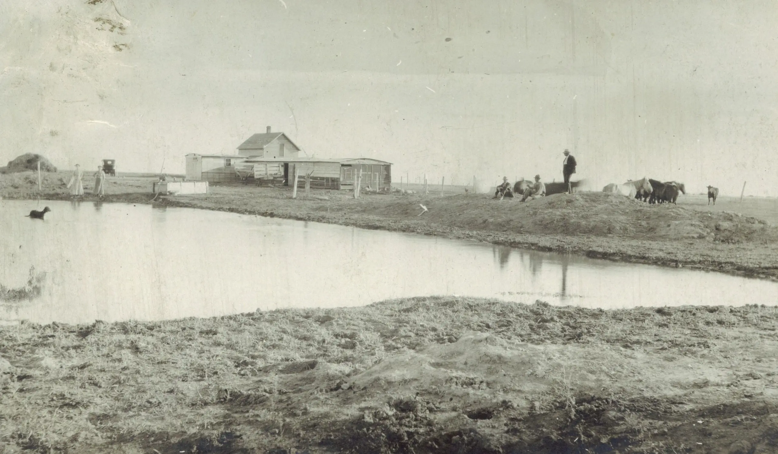 Farmstead and slough with horses and people